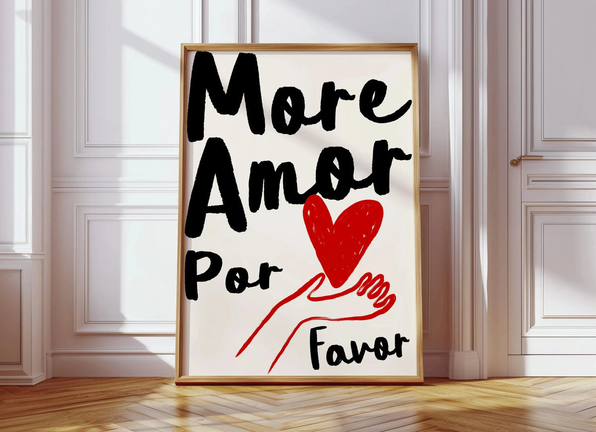 A framed canvas print featuring the text More Amor Por Favor written in black and red on a white background.