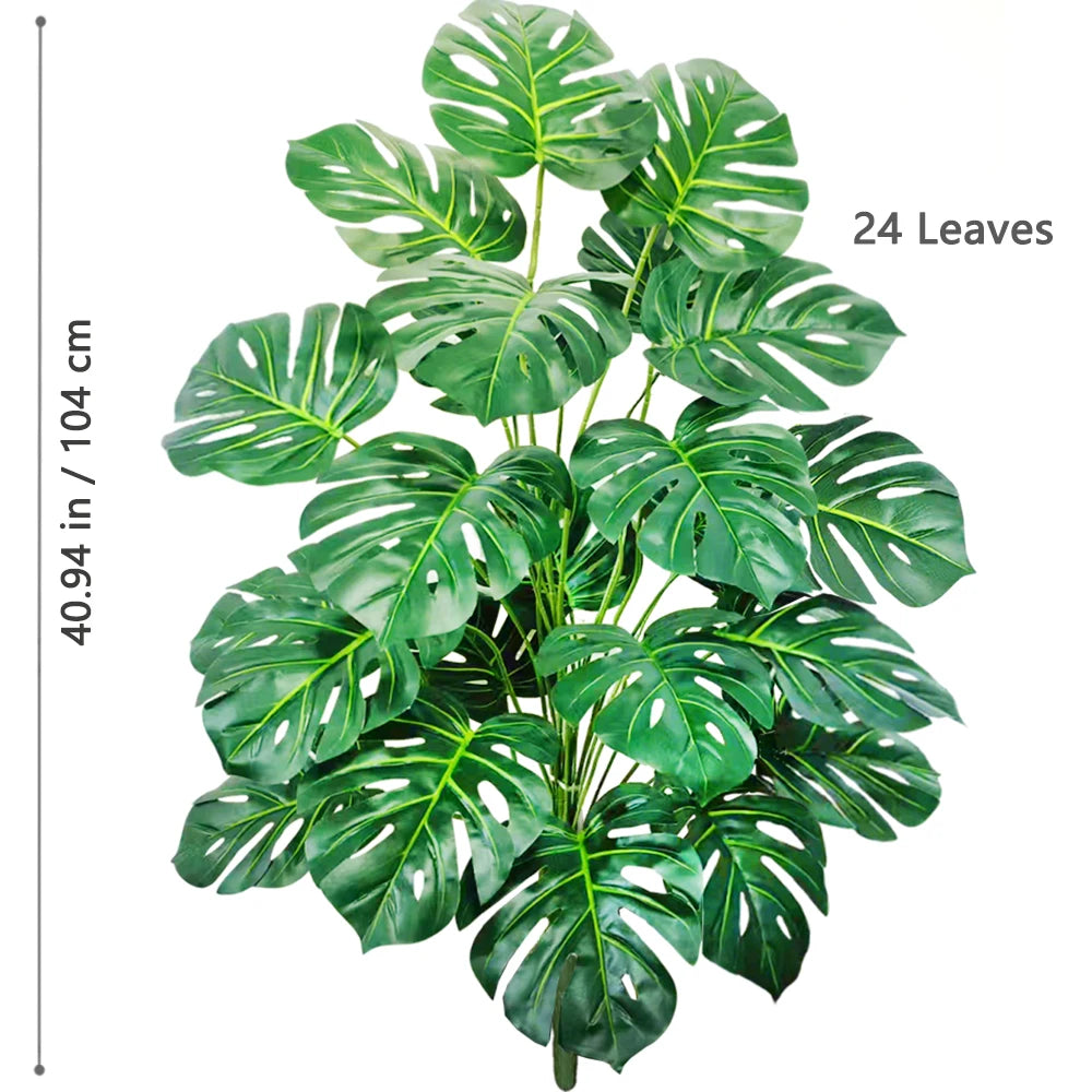A lush green artificial Monstera plant with 24 silk leaves used for home and office decor.