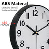 A close-up view of a black and white analog clock with an ABS frame and hands.