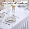 White table setting with a white stretched tablecloth featuring plates, silverware, and a bottle of olive oil.