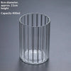 A clear cylindrical glass container with vertical ridges, used as a decor vase.