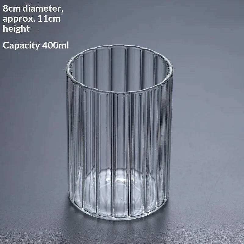 A clear cylindrical glass container with vertical ridges, used as a decor vase.