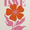 A graphic design featuring the text The world needs more LOVE and an orange flower with pink leaves.