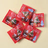 A collection of red festive bags with Christmas themes and animal figurines, ready to be opened.