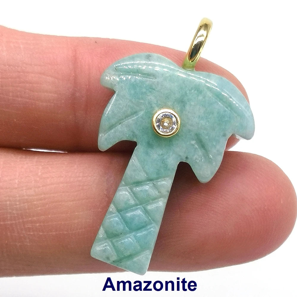 A light green amazonite crystal shaped like a palm frond with a gold-colored zircon charm on a silver-toned pendant.