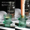 Porta velas de cristal verde con textura y vela pillar.
