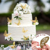 A tiered white cake decorated with gold butterflies and white flowers on a silver stand.