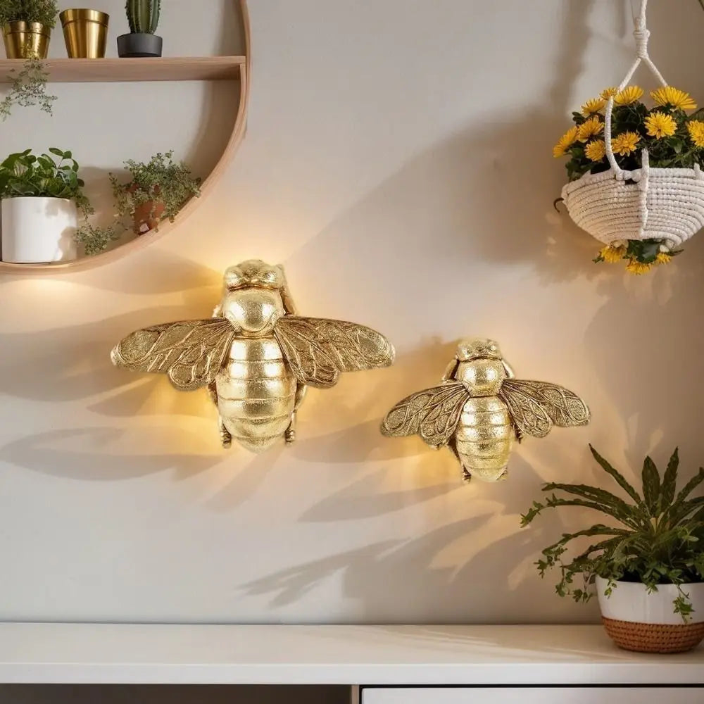 Handgefertigte goldene Bienenwandskulptur, montiert an einer hellen Wand.