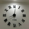 A large black acrylic wall clock face with Roman numerals and hands displaying the time.