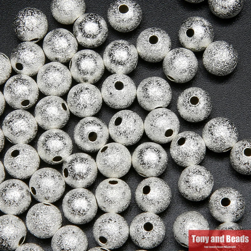 A close-up view of silver plated brass stardust round beads for jewelry making