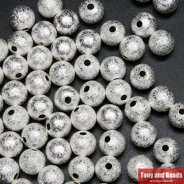 Gros plan de perles rondes en laiton plaqué argent pour la fabrication de bijoux
