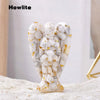 A natural crystal guardian angel figurine made of white and gray marbled stone with gold accents.