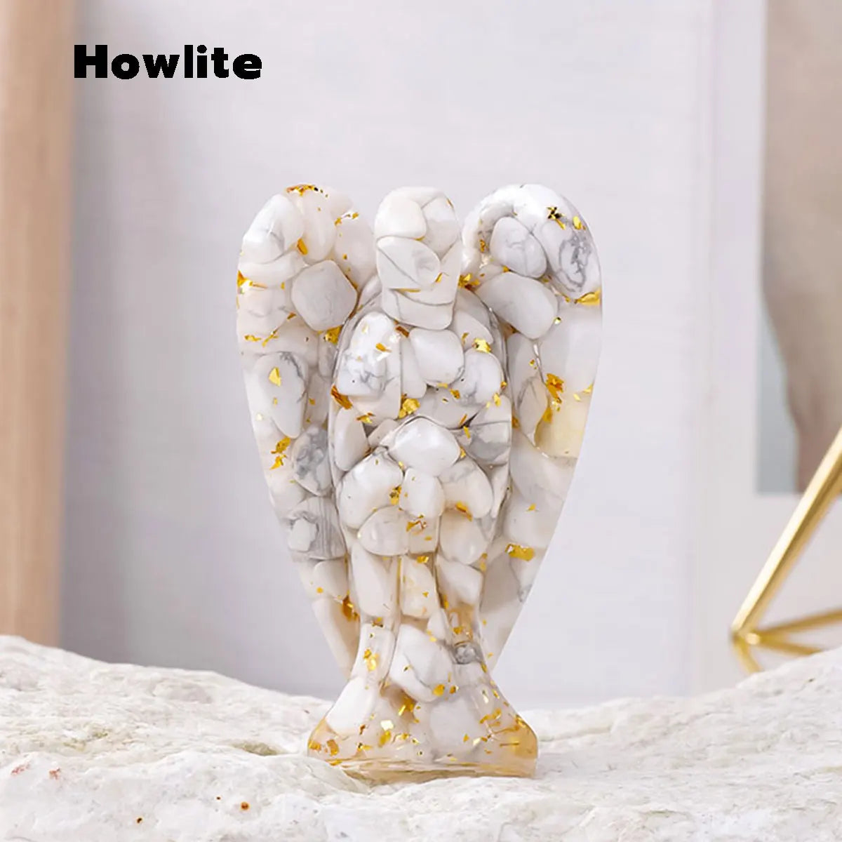 A natural crystal guardian angel figurine made of white and gray marbled stone with gold accents.