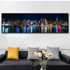 A canvas print depicting the New York City skyline at night with city lights reflecting on water.