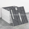 A stack of gray and white marble peel-and-stick tile stickers with silver accents displayed on a concrete surface.