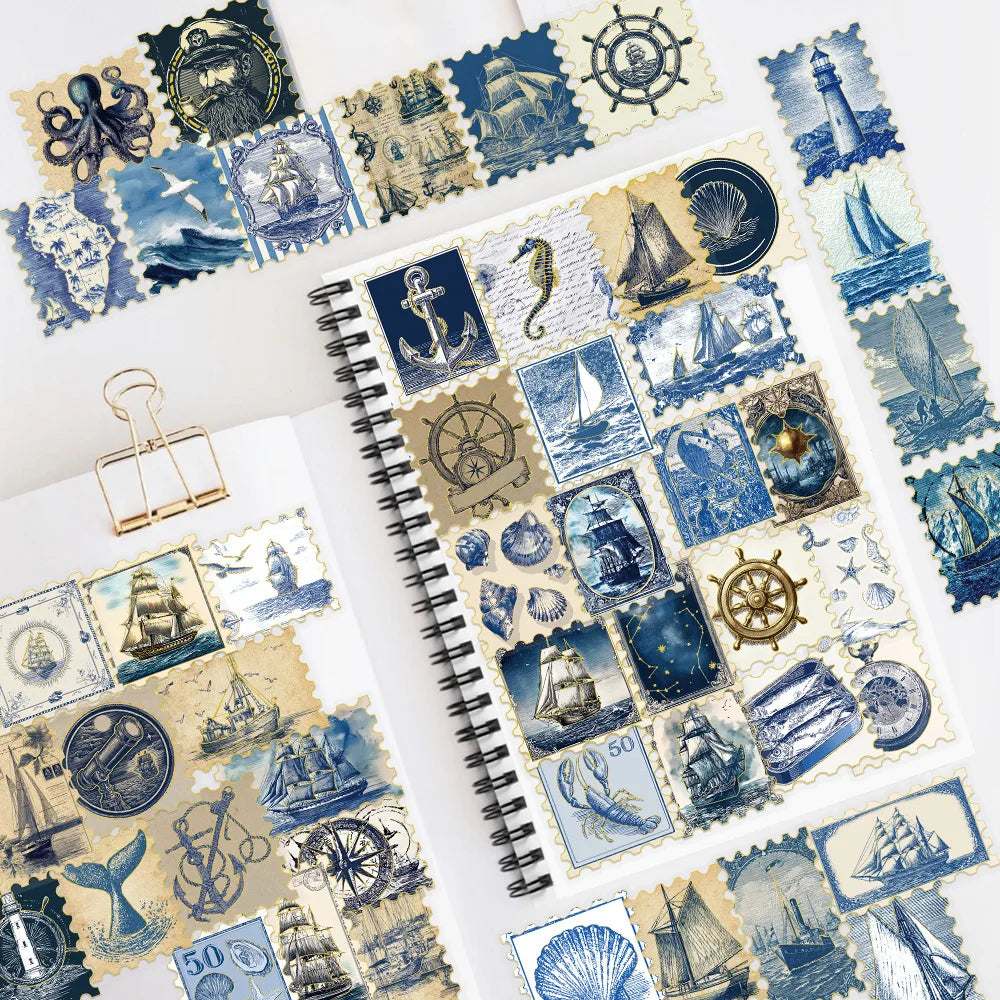 A collection of retro nautical foil decorative stickers featuring ships, anchors, and lighthouses on a spiral notebook.
