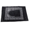 Black prayer mat with an ornate geometric border and a compass design.