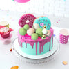 A vibrant pink and teal layer cake decorated with foam ball toppers and sprinkles for a party.