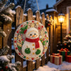 A round pearl diamond painting ornament featuring a white snowman with a red scarf and green accents, hanging on a wooden fen