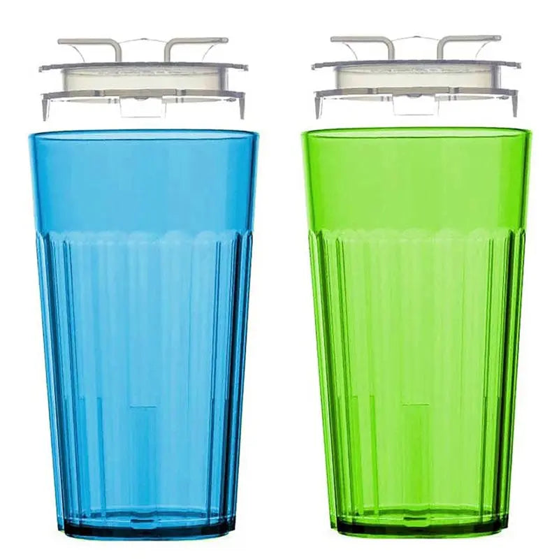 A pair of clear plastic Montessori training cups, one blue and one green, shown with their lids.