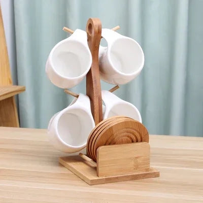 A set of white ceramic coffee mugs displayed on a natural bamboo wood stand.