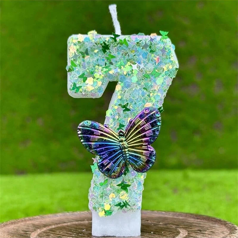 A number seven candle decorated with green sequins and a purple butterfly on a wooden surface.