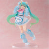 A PVC collectible figurine of Hatsune Miku with teal hair, a pink bow, and a light blue outfit.