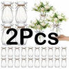 Two clear faceted diamond crystal plastic vases with floral arrangements.