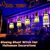 Halloween decorations featuring glowing ghost witch hats hanging on a porch during twilight.