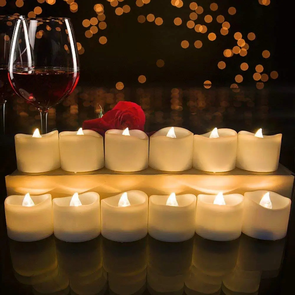 Eine Reihe leuchtender weißer Teelichter auf einer Holzoberfläche mit einem Glas Rotwein im Hintergrund.