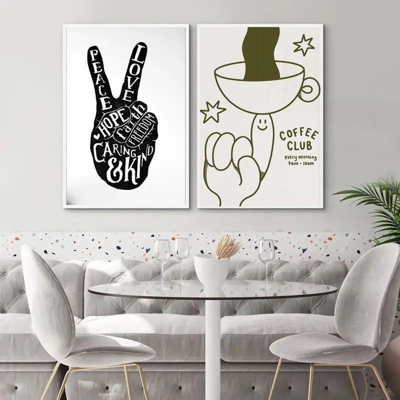 Un set de dos impresiones en lienzo pintadas a mano en blanco y negro con símbolos de paz y amor y un diseño de taza de café.
