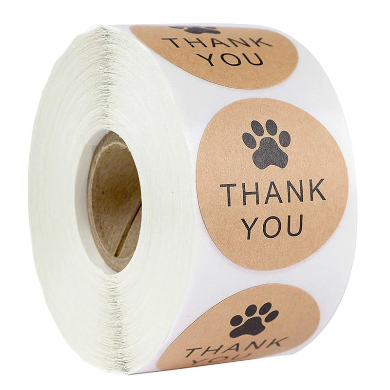 Roll of kraft paper thank you stickers with paw prints and the text thank you