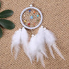 Handmade boho feather dream catcher with white hoop and colorful beads hanging on a burlap background