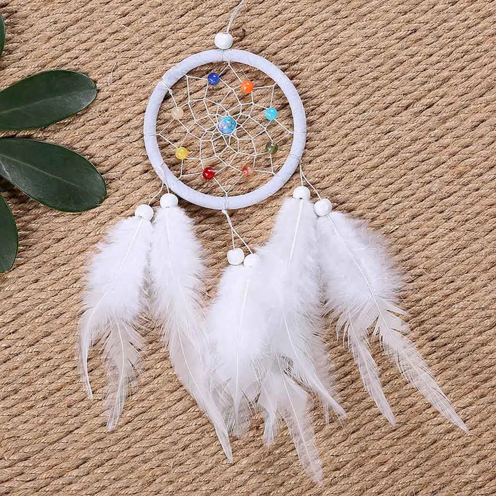 Handmade boho feather dream catcher with white hoop and colorful beads hanging on a burlap background