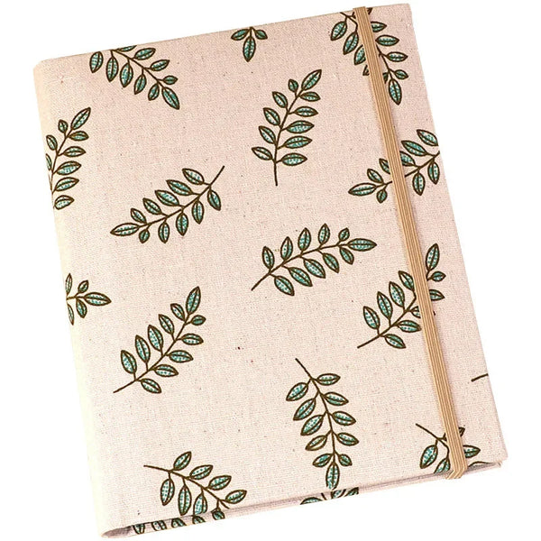 A beige linen photo album with a patterned cover featuring green leaves.
