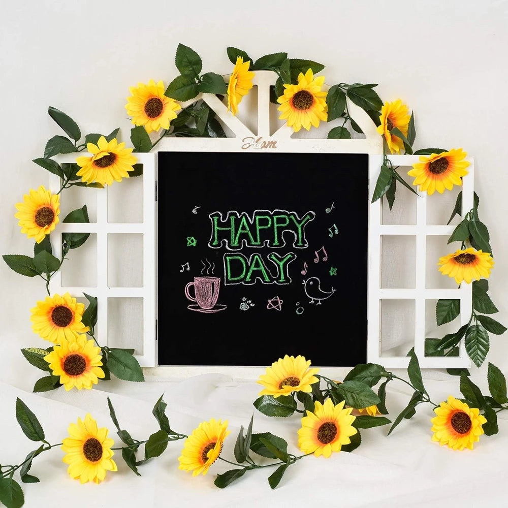 A white wooden frame decorated with yellow silk sunflowers and green vines for home decor.