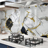 A kitchen backsplash featuring marble white and gold veining on a wall, with a modern stovetop below.