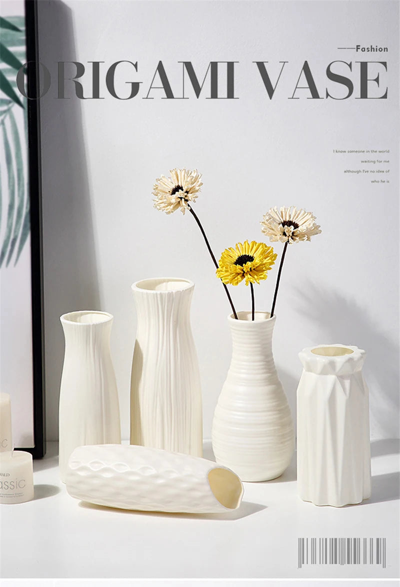 A collection of white plastic vases in various shapes and textures displayed against a light background.