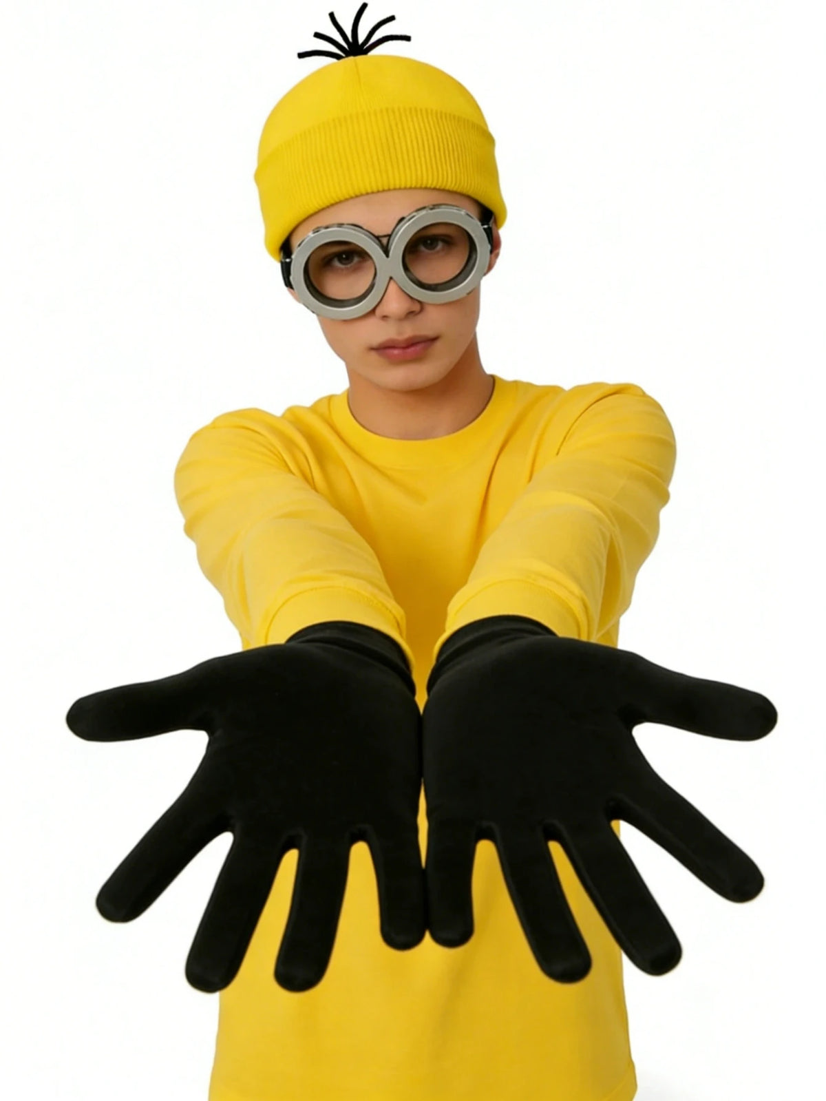 A person wearing a yellow sweater, black gloves, and round glasses with a spiky hat for a costume.