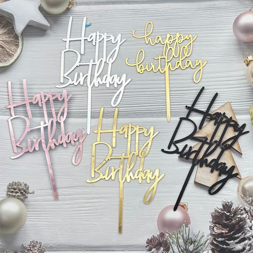 A set of elegant black and gold acrylic cake toppers for birthday parties displayed on a light wooden surface.