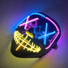 A black mask with neon pink and blue LED lines glowing on a wall.