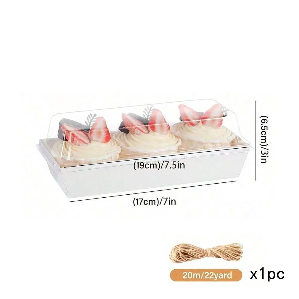 Clear plastic box containing three pink meringue pastries with green leaves and a twine bow
