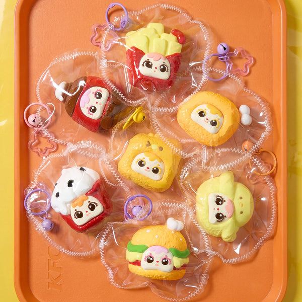 A collection of colorful, themed squeeze toys in clear plastic bags displayed on an orange tray.