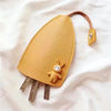 A tan cartoon PU leather key holder with a pull-out design attached to a brown leather cord.