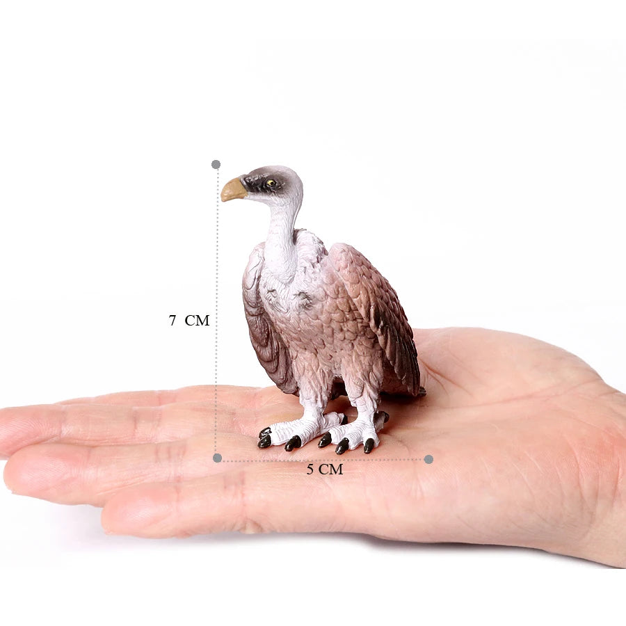 A realistic figurine of an owl or vulture perched on a human hand, showing its size with a scale.