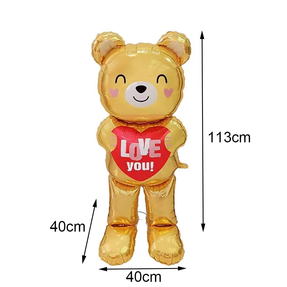 A golden teddy bear balloon with a red heart saying Love you on it.