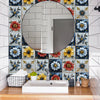 A bathroom vanity featuring a white sink and a large circular mirror surrounded by colorful floral tiles.