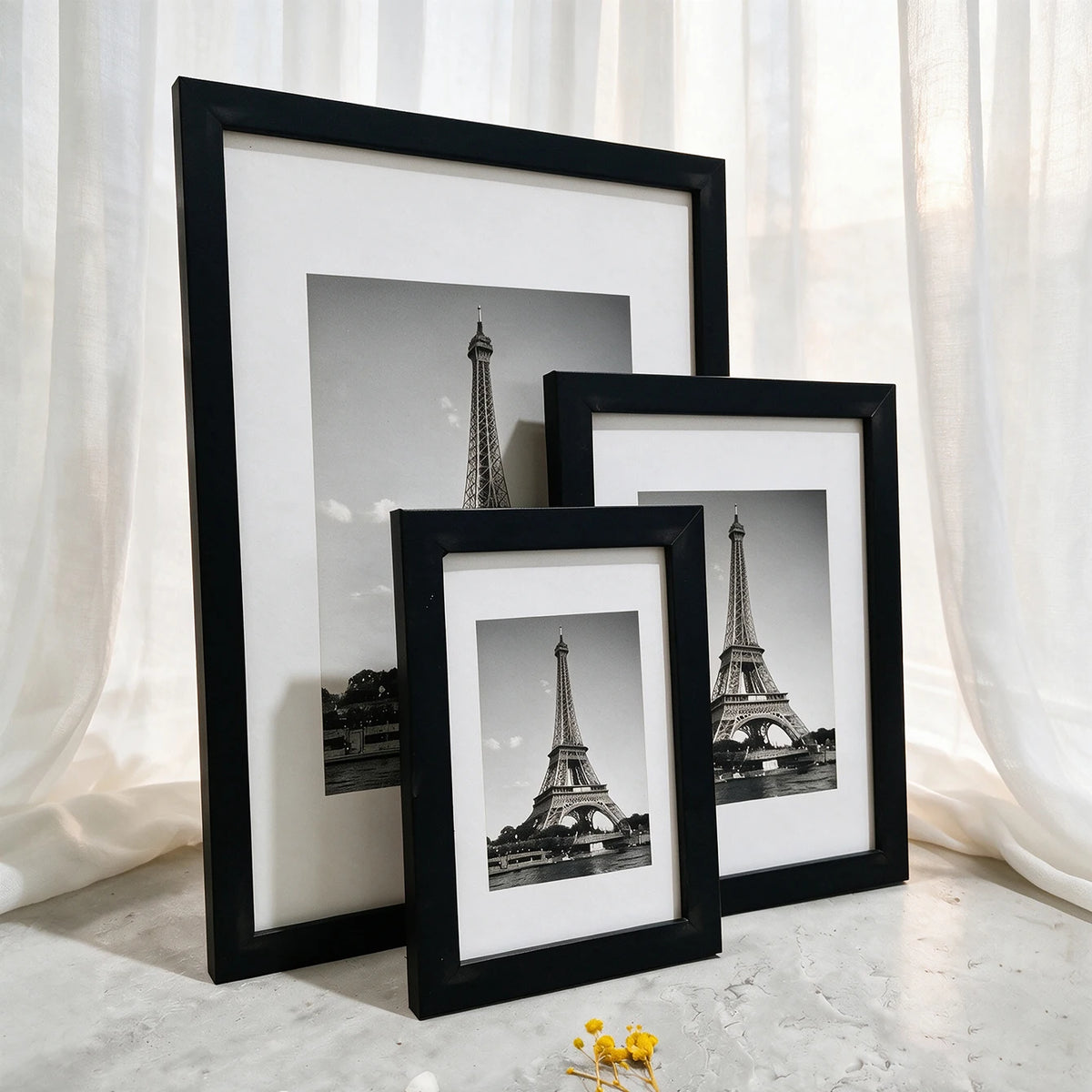 A set of three black and white photo frames displaying the Eiffel Tower.