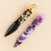 A decorative piece featuring an obsidian blade and a purple amethyst crystal ball with gold accents.