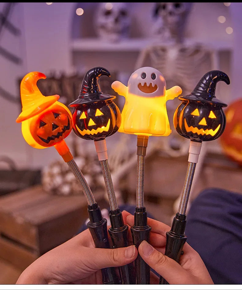 Une main tient quatre lanternes d'Halloween orange et jaunes lumineuses avec des visages sculptés, sur un arrière-plan flou.